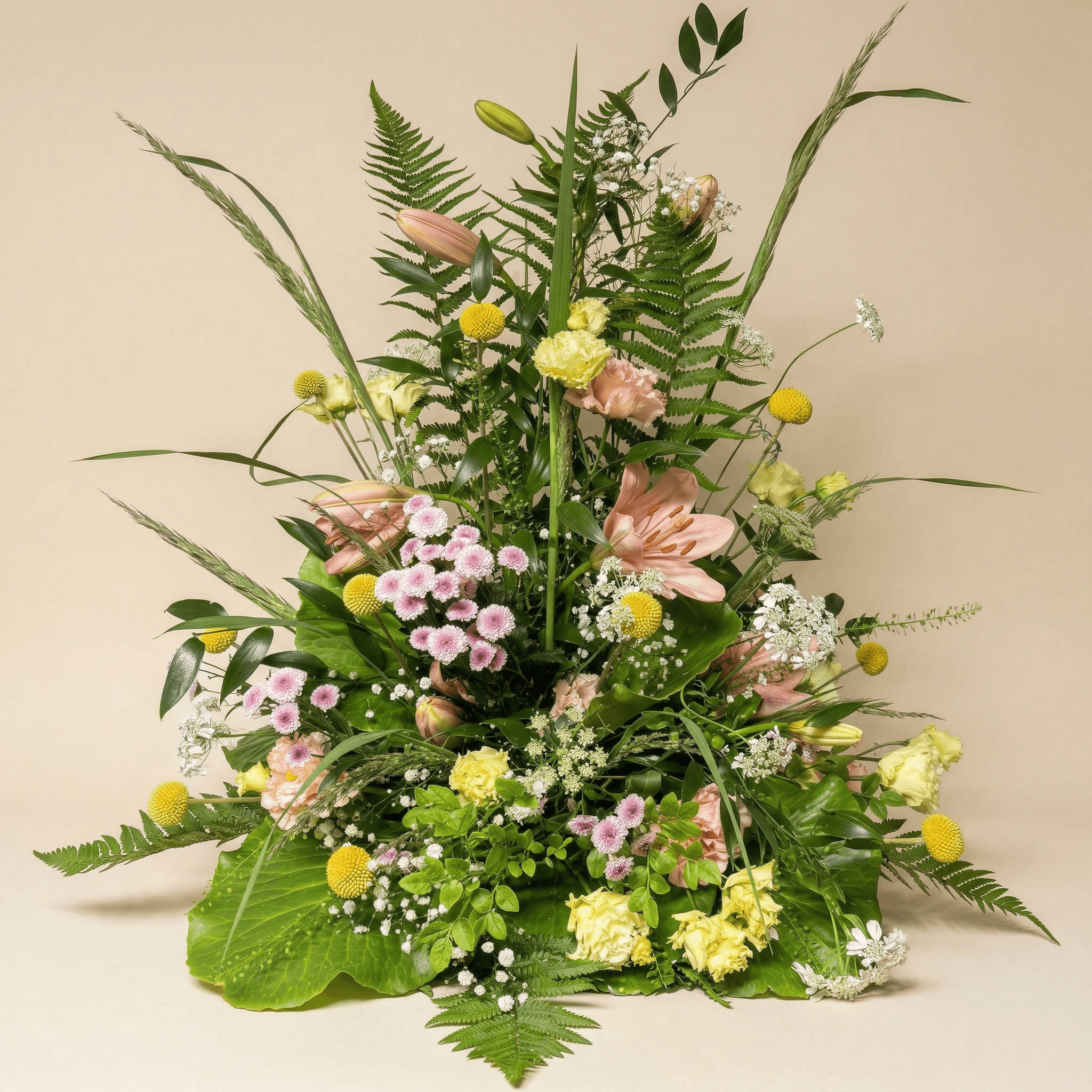 Stående sorgarrangemang med rosa liljor