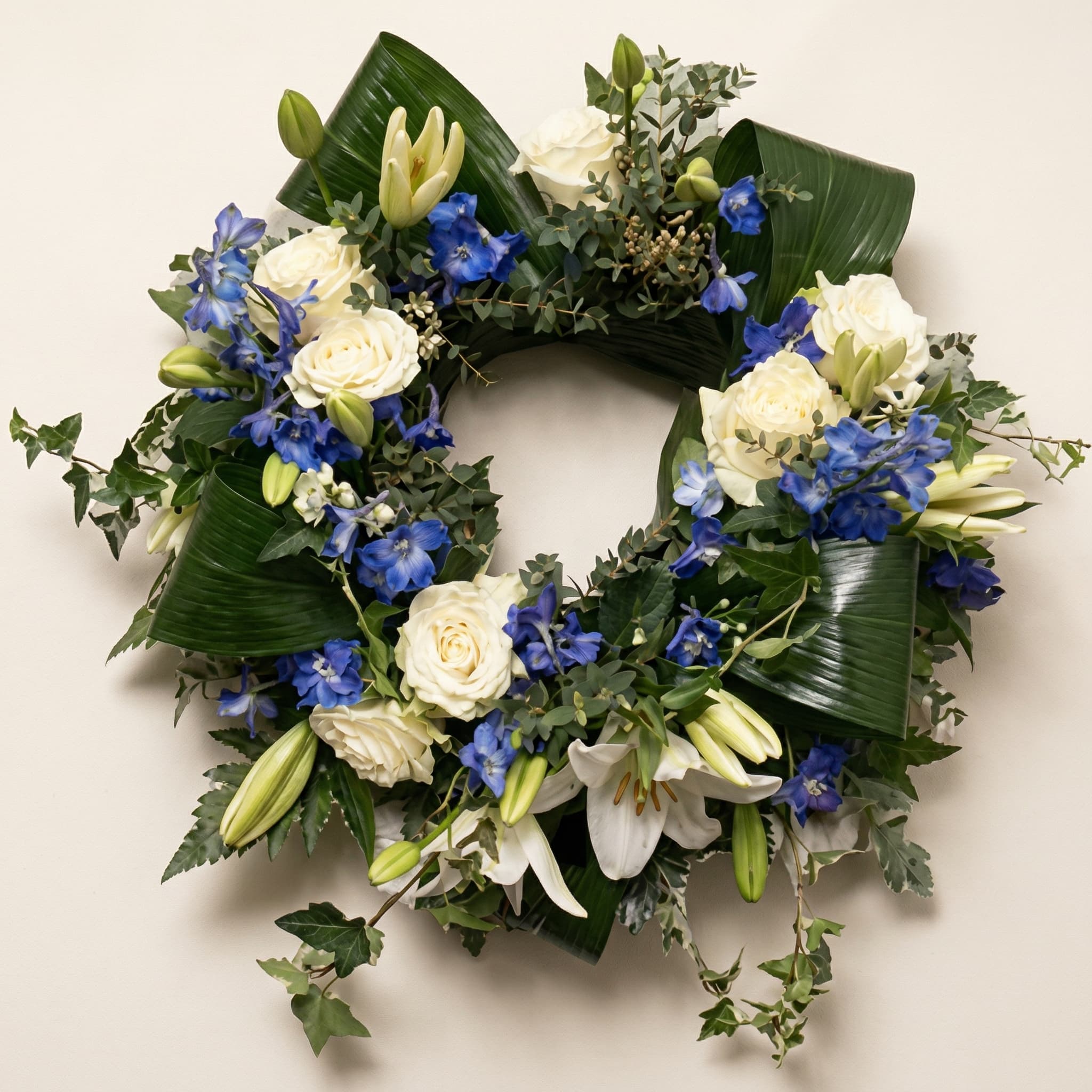 Krans med vita rosor och blå riddarsporrar