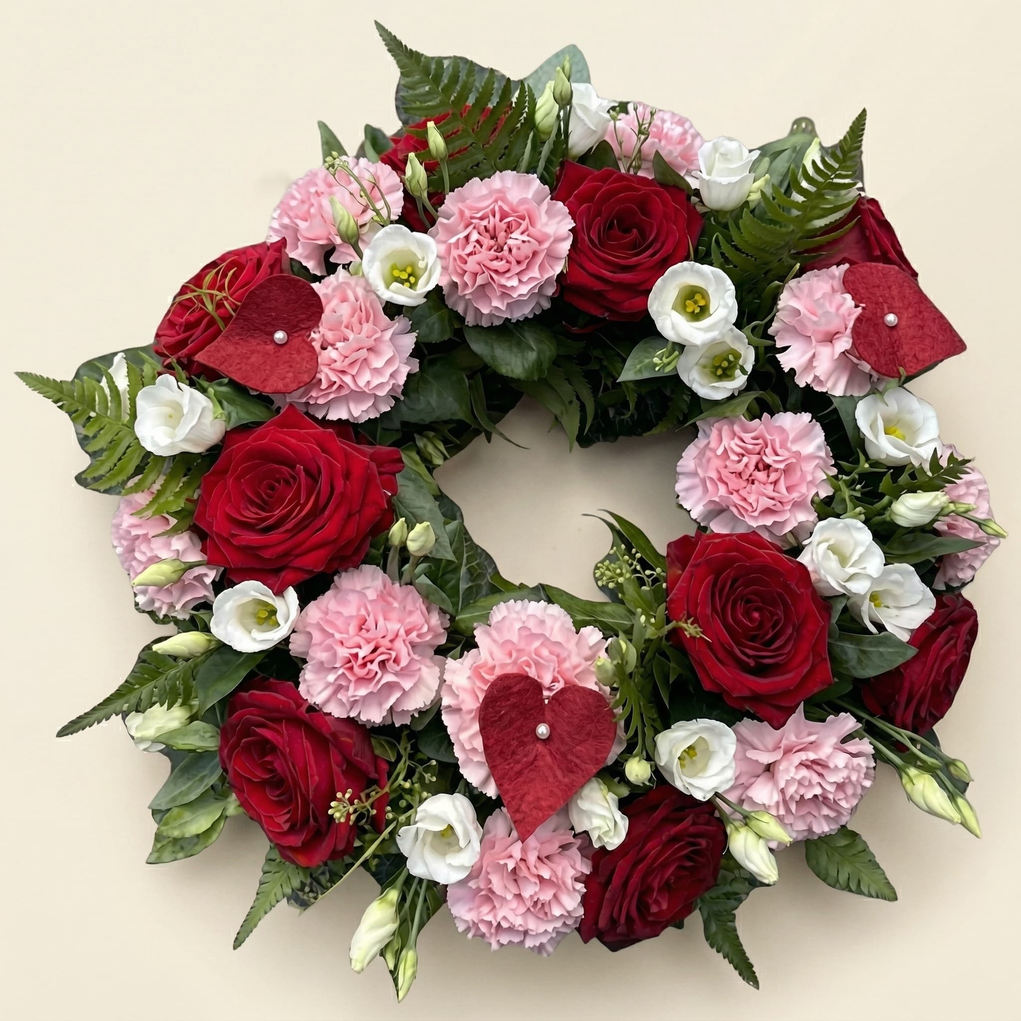 Krans med röda rosor och rosa nejlikor